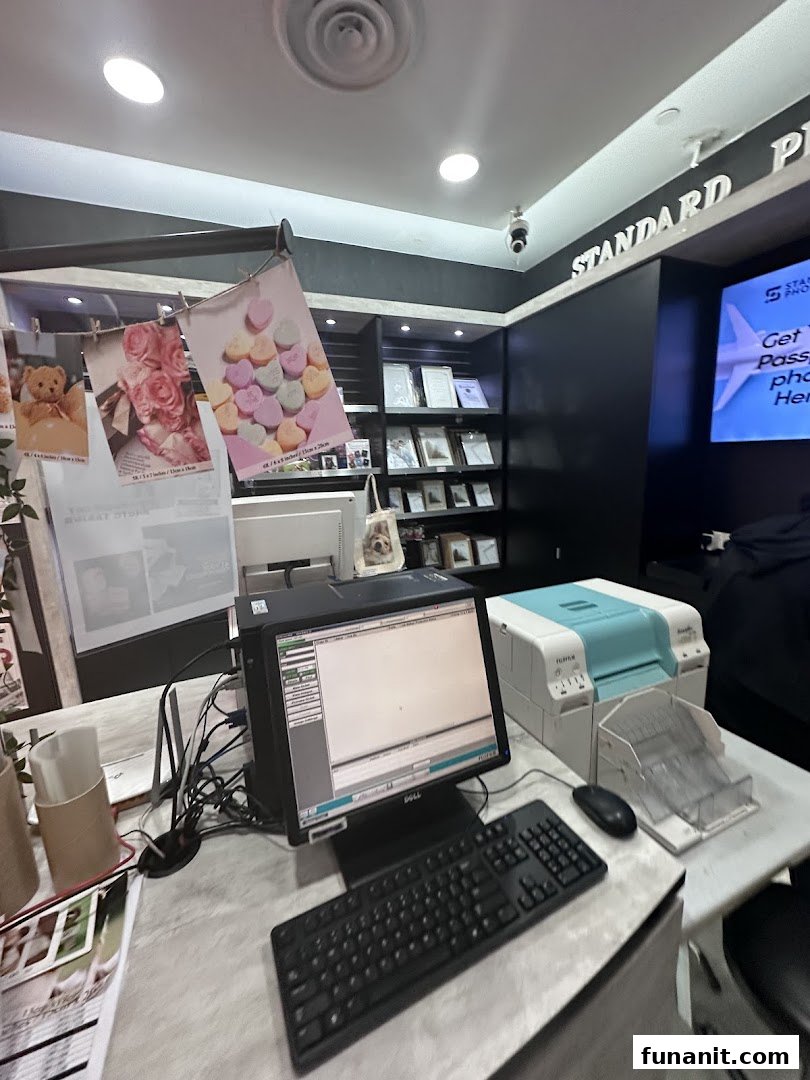 A photo printing service counter with computers, printers, and sample prints at Standard Photo Funan.