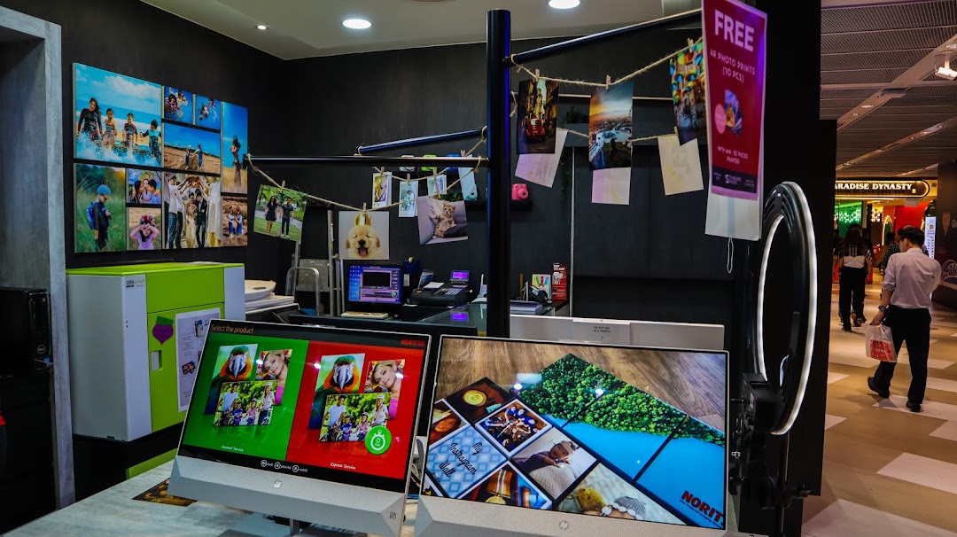 Interior of Standard Photo Funan, showcasing self-service photo printing kiosks, sample prints, and a service counter.