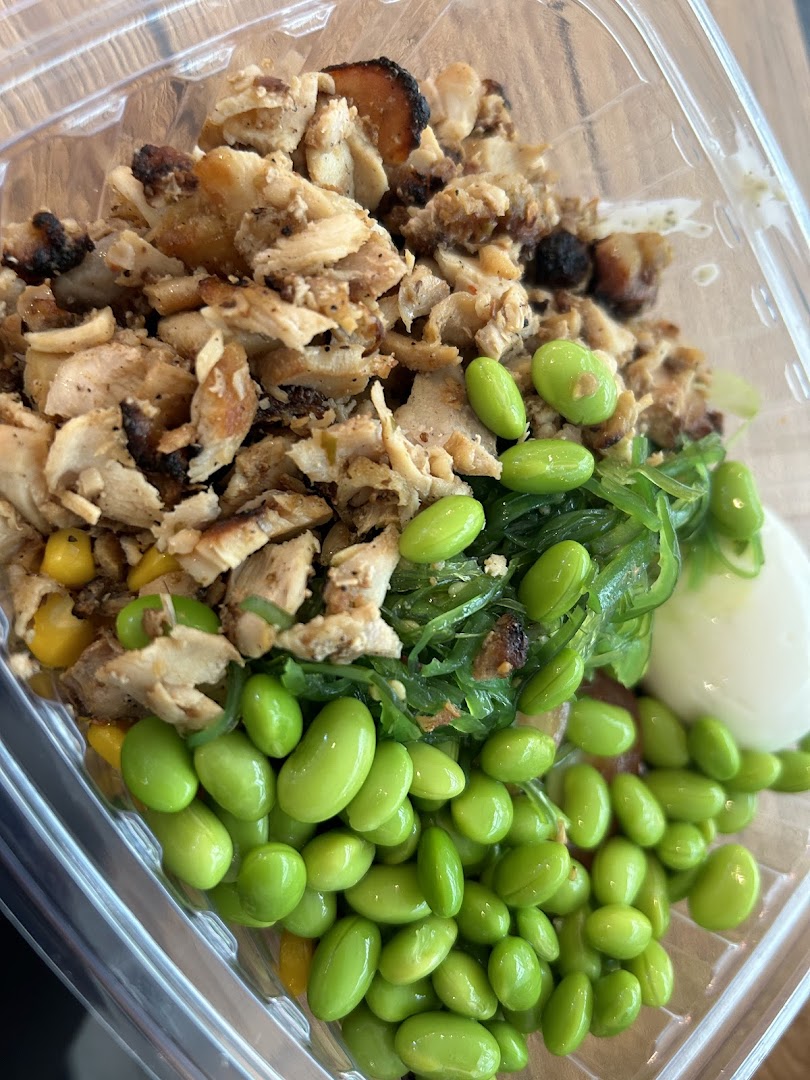 A vibrant, healthy food bowl from Stuffd featuring chicken, edamame, and seaweed salad.