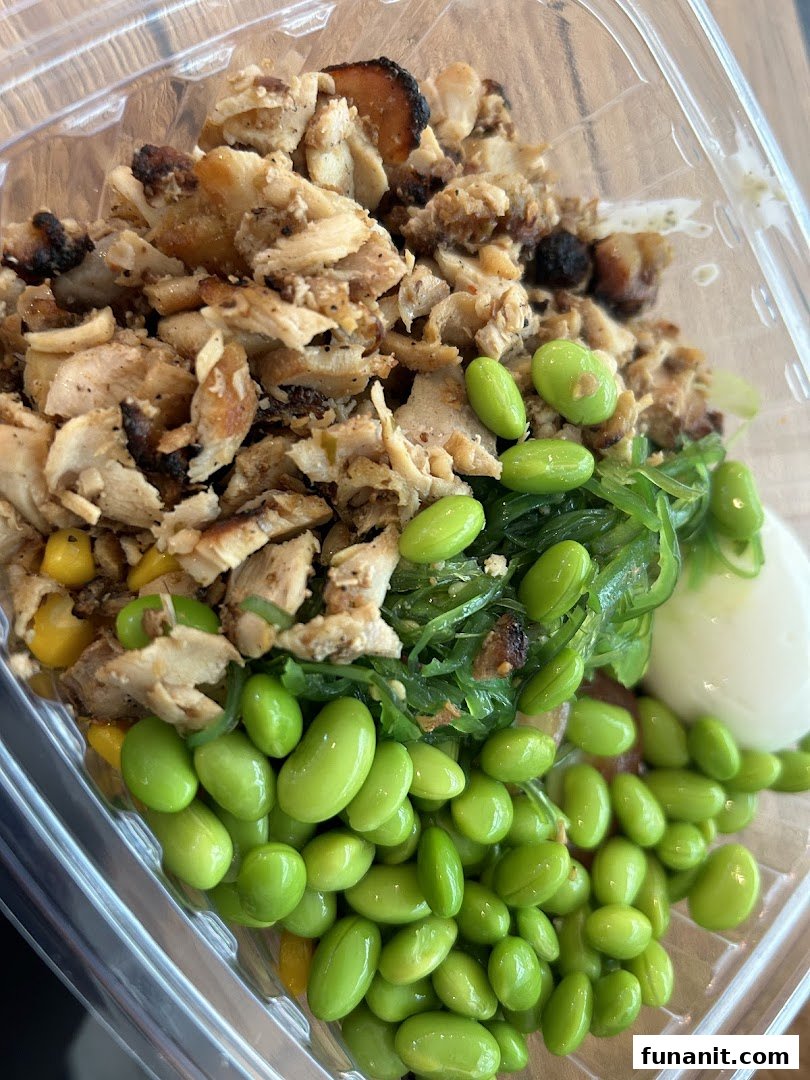 A vibrant, healthy food bowl from Stuffd featuring chicken, edamame, and seaweed salad.