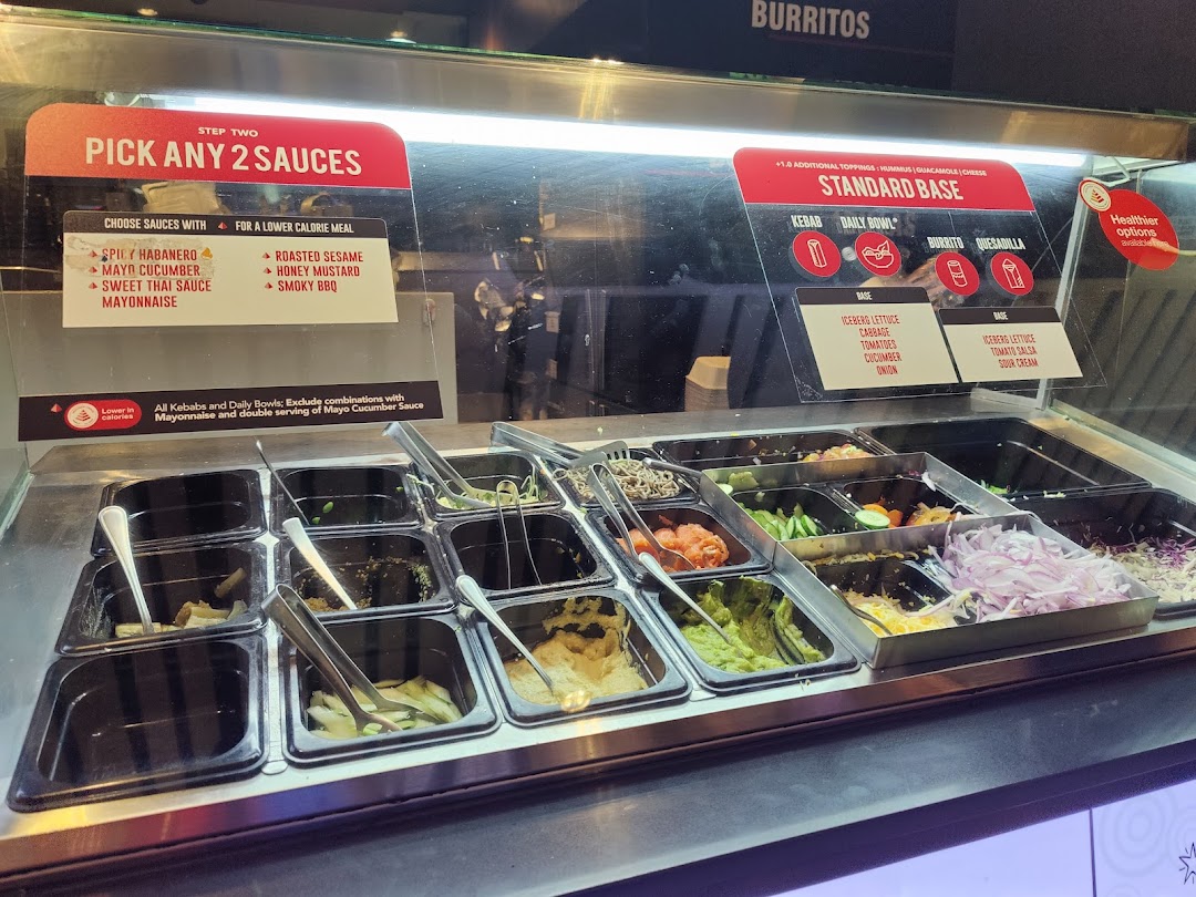 A vibrant food counter showcasing fresh ingredients and clear menu options for custom-built meals at Stuffd.