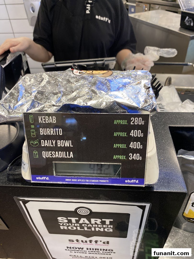 A counter display at Stuffd showing approximate weights for Kebab, Burrito, Daily Bowl, and Quesadilla.