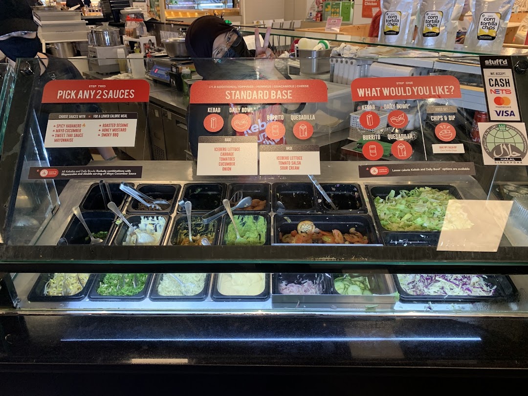 A vibrant counter at Stuffd showcasing fresh ingredients, customizable options, and menu displays.