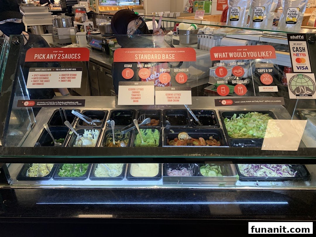 A vibrant counter at Stuffd showcasing fresh ingredients, customizable options, and menu displays.