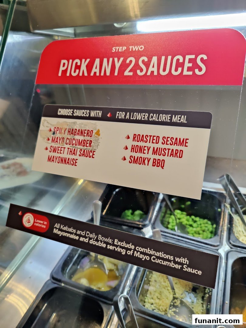 A sign at Stuffd displays sauce options and calorie guidance for custom meals.