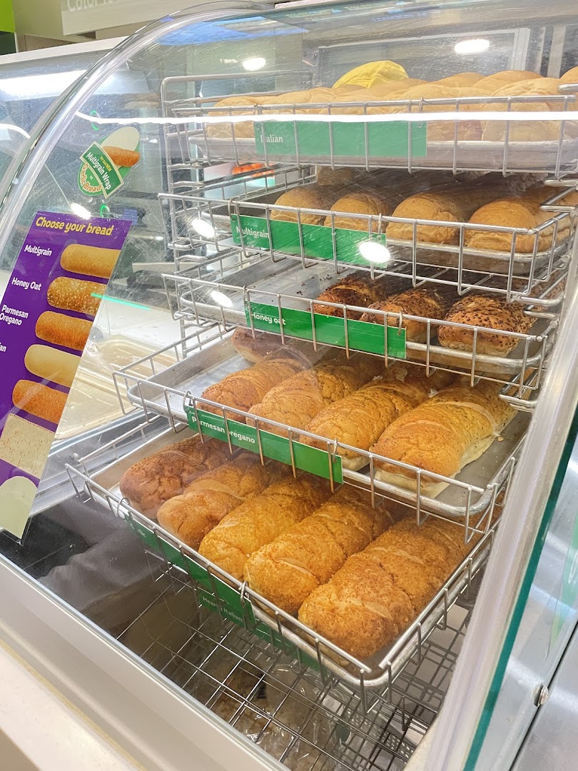 A display case at Subway showcasing various fresh bread options for sandwiches.