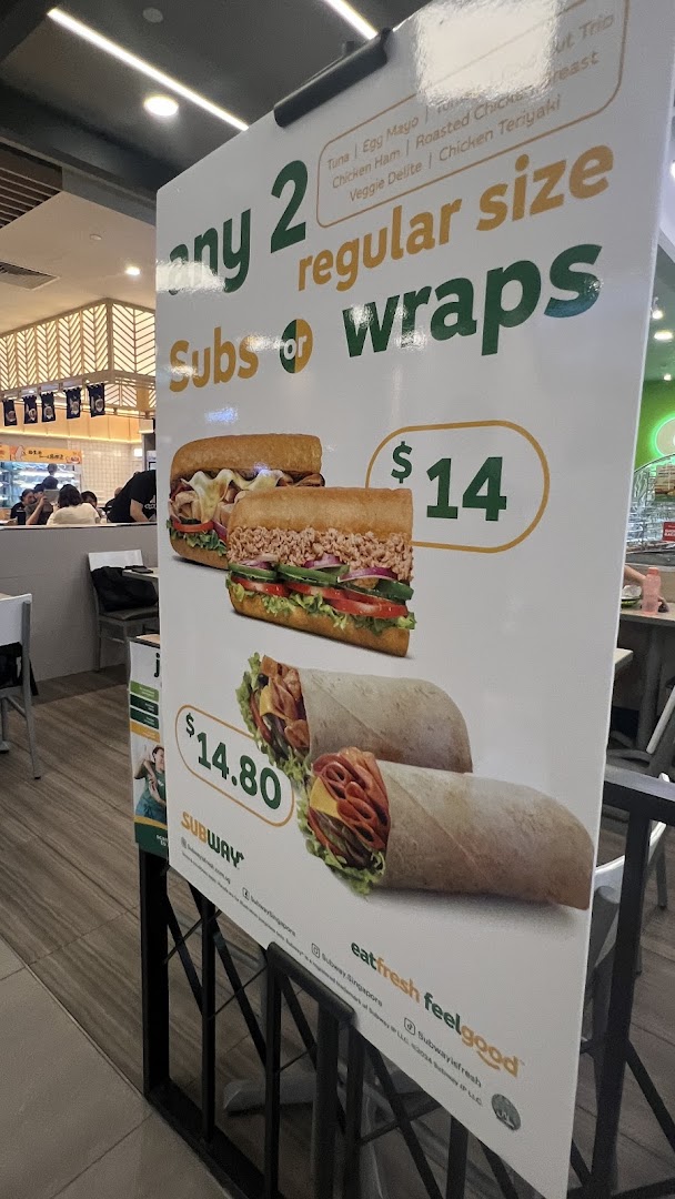 A promotional sign for Subway offering deals on two regular size subs or wraps.