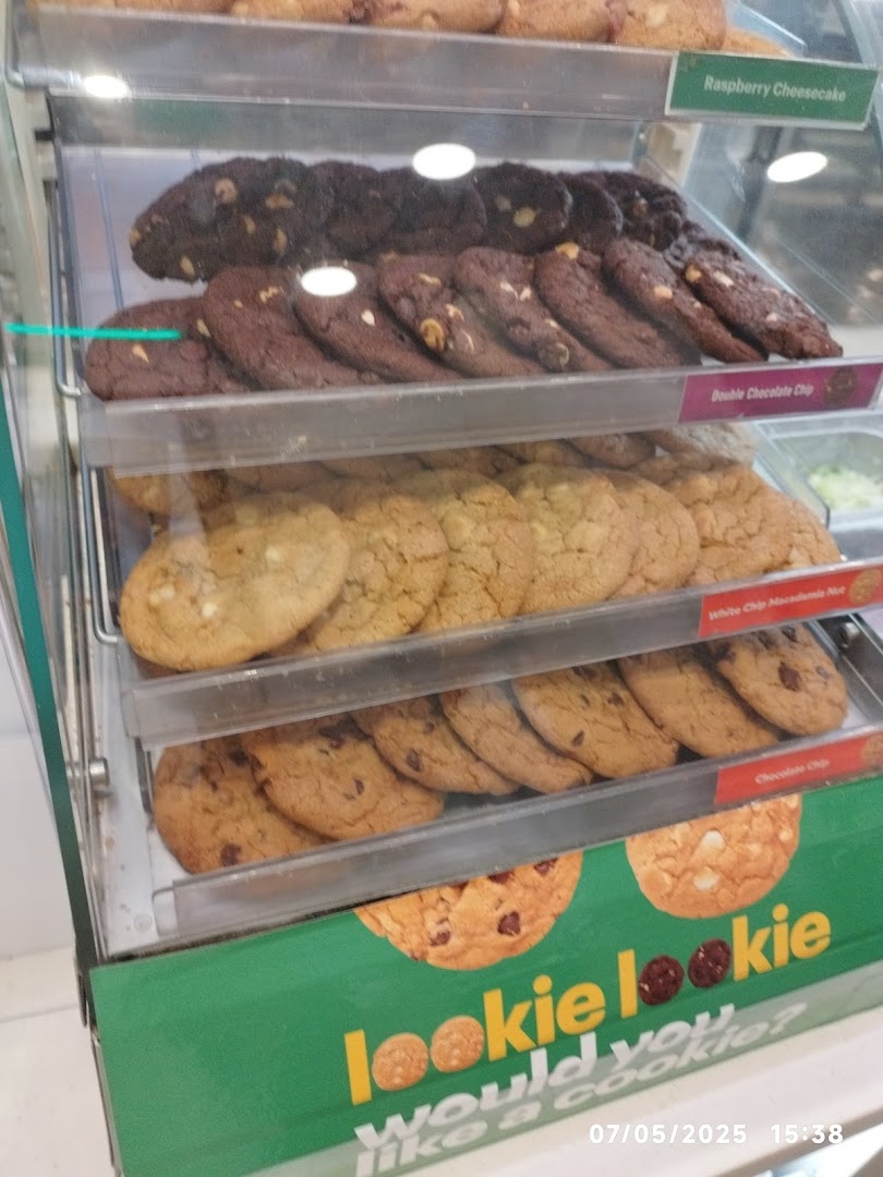 A vibrant display case showcasing a variety of freshly baked cookies at Subway.