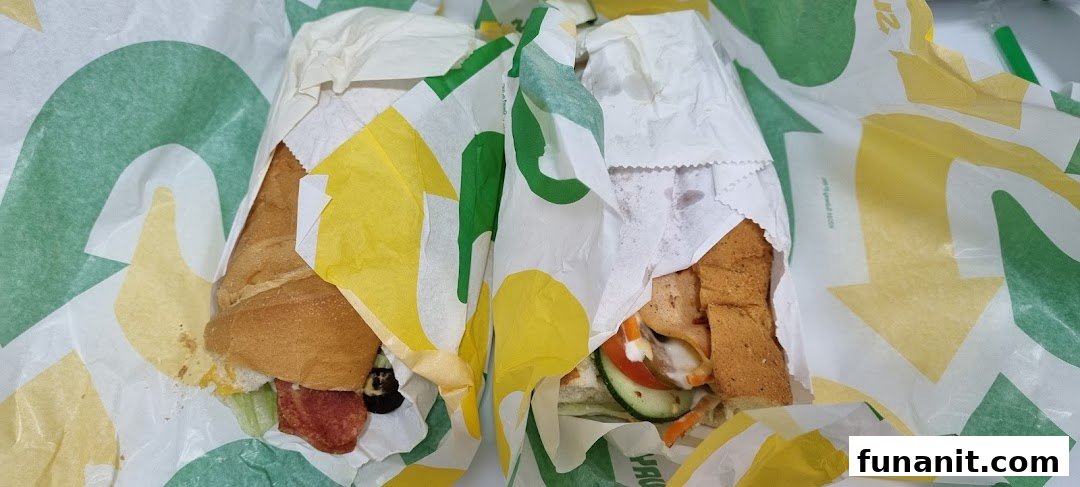 Two partially unwrapped Subway sandwiches, showcasing fresh ingredients and signature packaging.