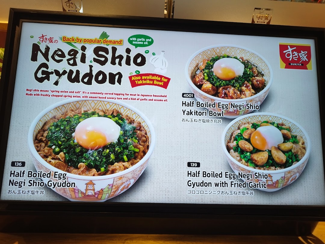 A Sukiya menu board showcasing Negi Shio Gyudon and other specialty bowls with eggs and toppings.