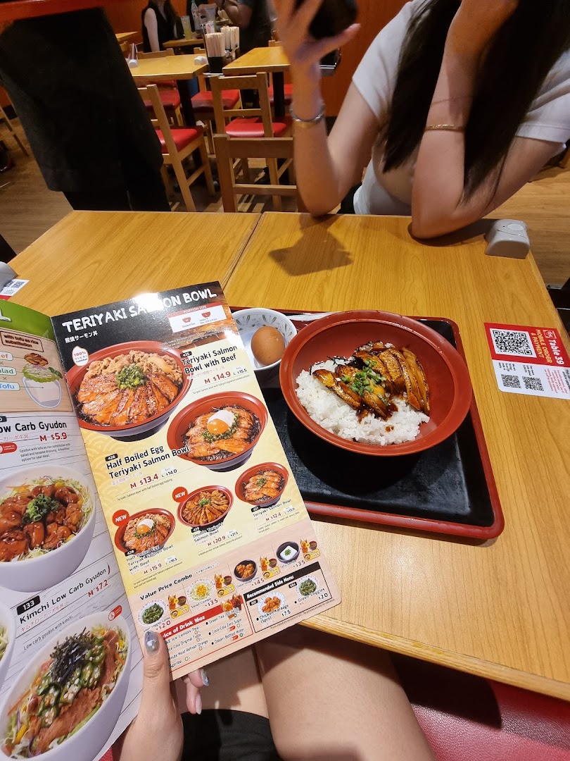 A customer's view of a Sukiya meal with a menu and a dish on a wooden table.