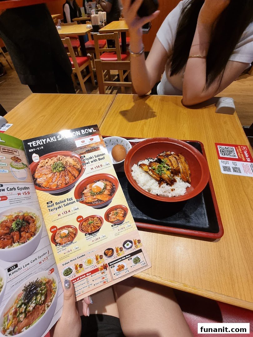 A customer's view of a Sukiya meal with a menu and a dish on a wooden table.