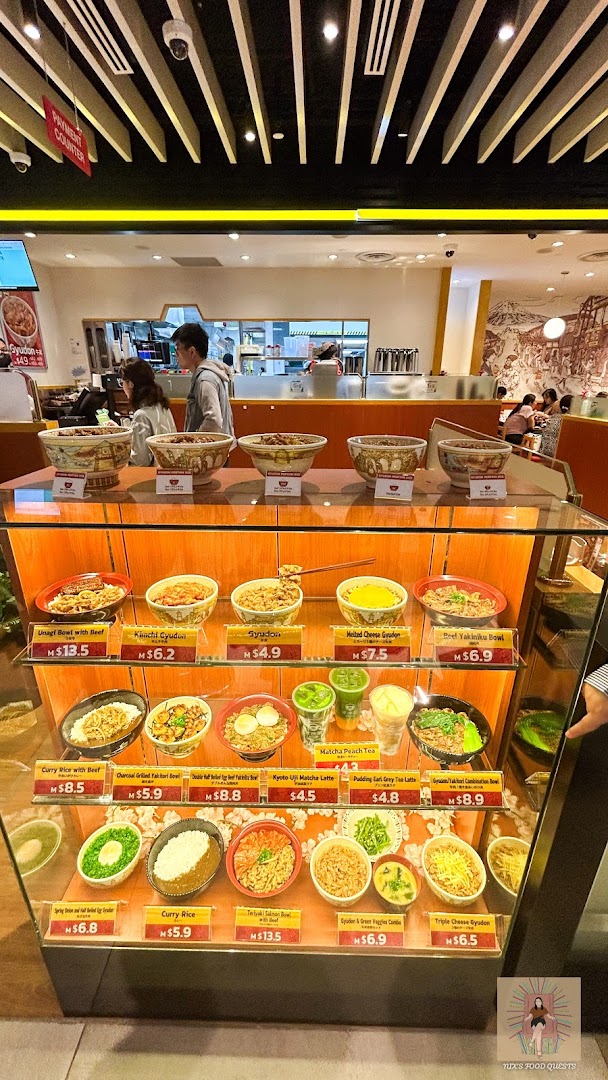 Interior view of Sukiya featuring a display case with various food models and prices.