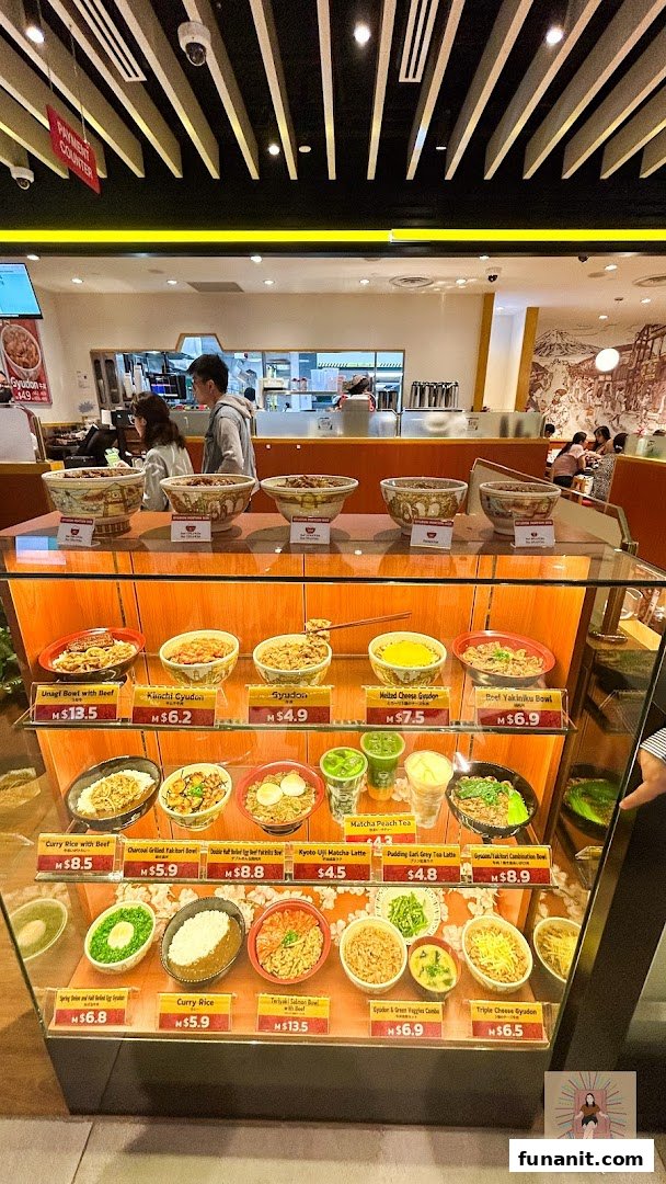 Interior view of Sukiya featuring a display case with various food models and prices.