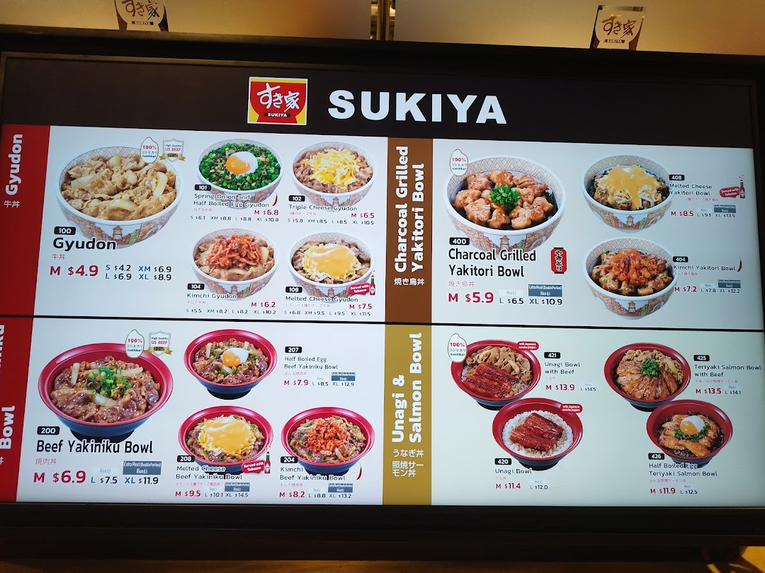 A brightly lit digital menu board displaying various Japanese rice bowls and their prices at Sukiya.