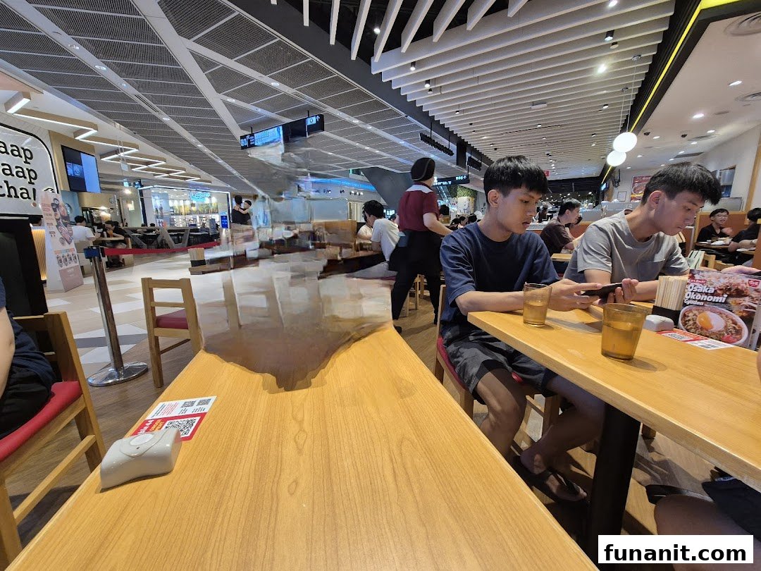 Customers dining at Sukiya, enjoying Japanese comfort food in a bright, spacious setting.