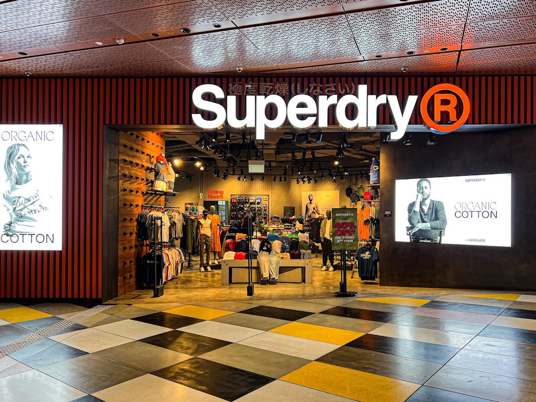 The Superdry shop front with its prominent logo, displaying clothing and 'Organic Cotton' signage.