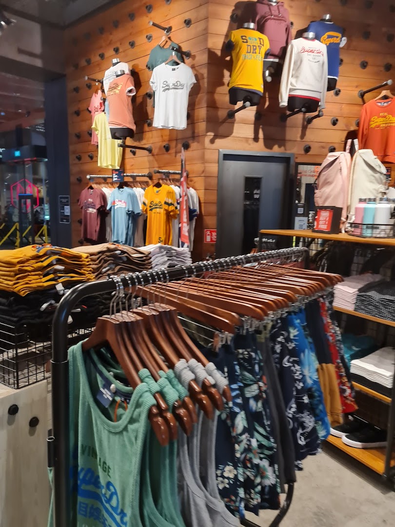 Interior view of a Superdry store showcasing a wide range of casual apparel on racks and wall displays.