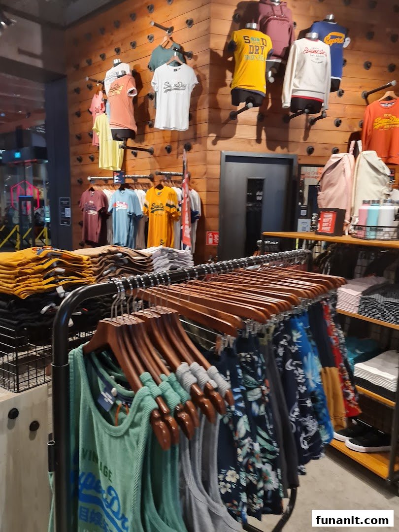 Interior view of a Superdry store showcasing a wide range of casual apparel on racks and wall displays.