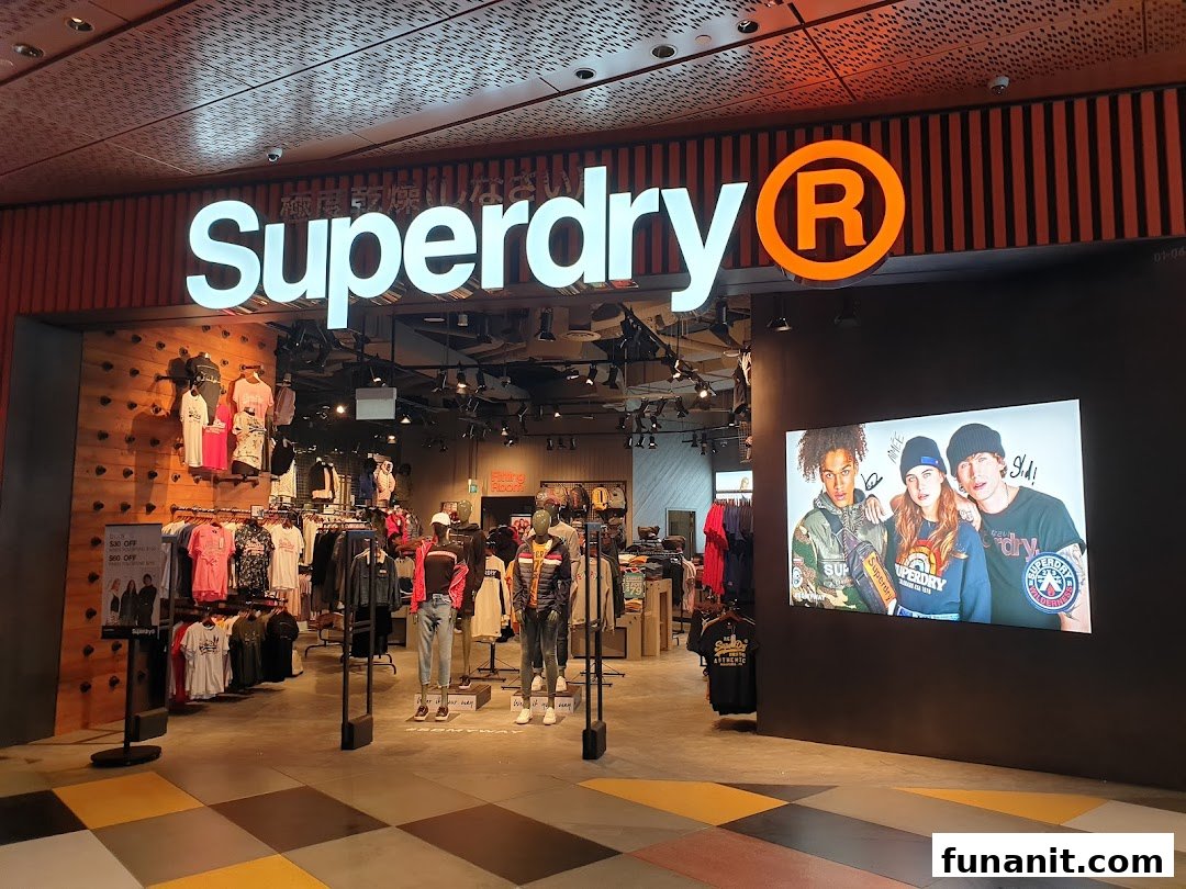 The Superdry shop entrance with its illuminated logo, displaying clothing and a large digital screen.