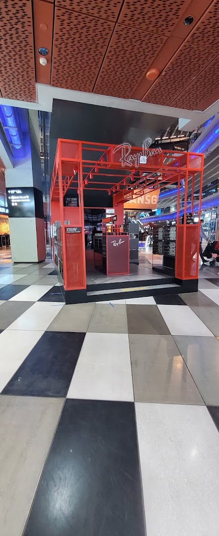 A vibrant red Ray-Ban kiosk showcasing eyewear in a modern mall setting.
