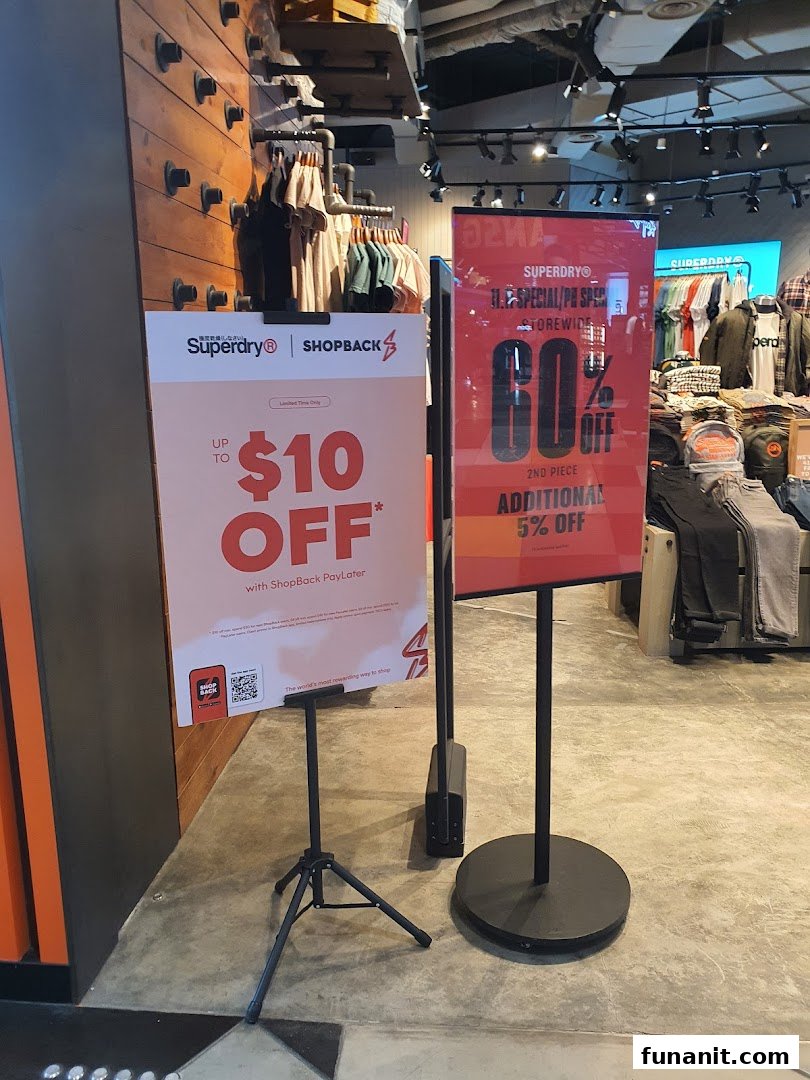Promotional signs and clothing displays inside a Superdry store, highlighting current offers.