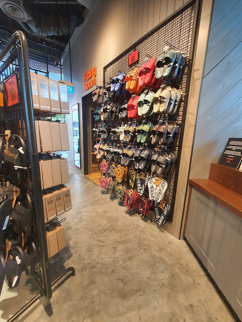 An interior shot of Superdry showcasing a vibrant display of sandals and slides near the fitting room.