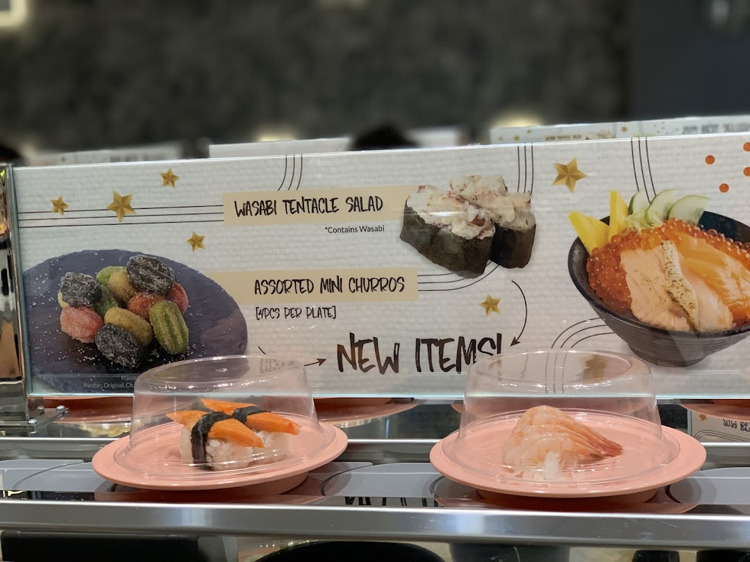 A display board showcasing new menu items and sushi on a conveyor belt at Sushi Express.