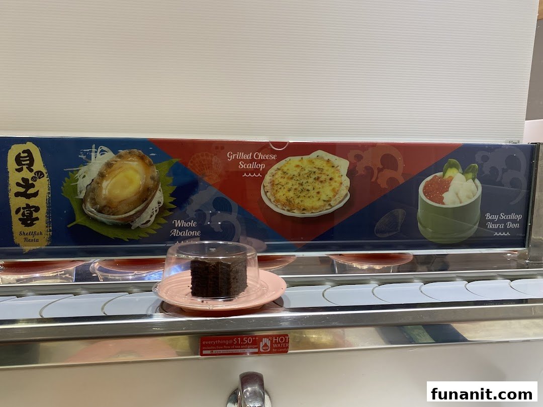 A close-up of Sushi Express's conveyor belt featuring a dessert and a display of premium seafood dishes.