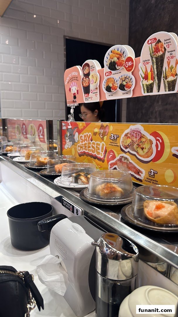 A vibrant interior shot of Sushi Express, showcasing a conveyor belt laden with various sushi dishes.