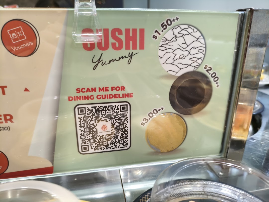 A Sushi Express sign displaying tiered sushi plate prices and a QR code for dining guidelines.