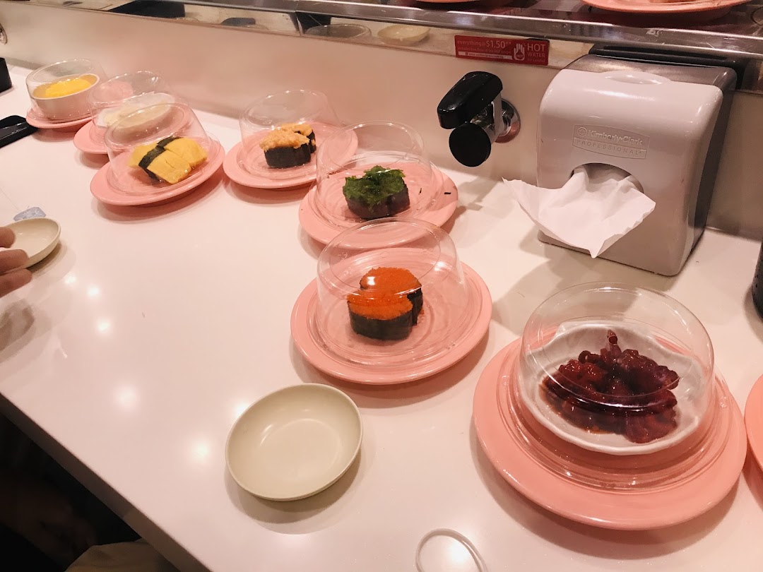 Sushi plates with various items on a conveyor belt at Sushi Express.