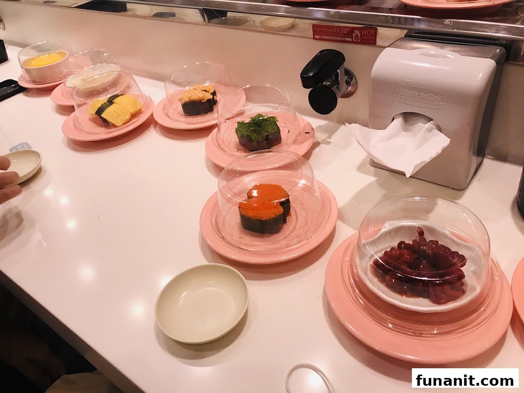 Sushi plates with various items on a conveyor belt at Sushi Express.