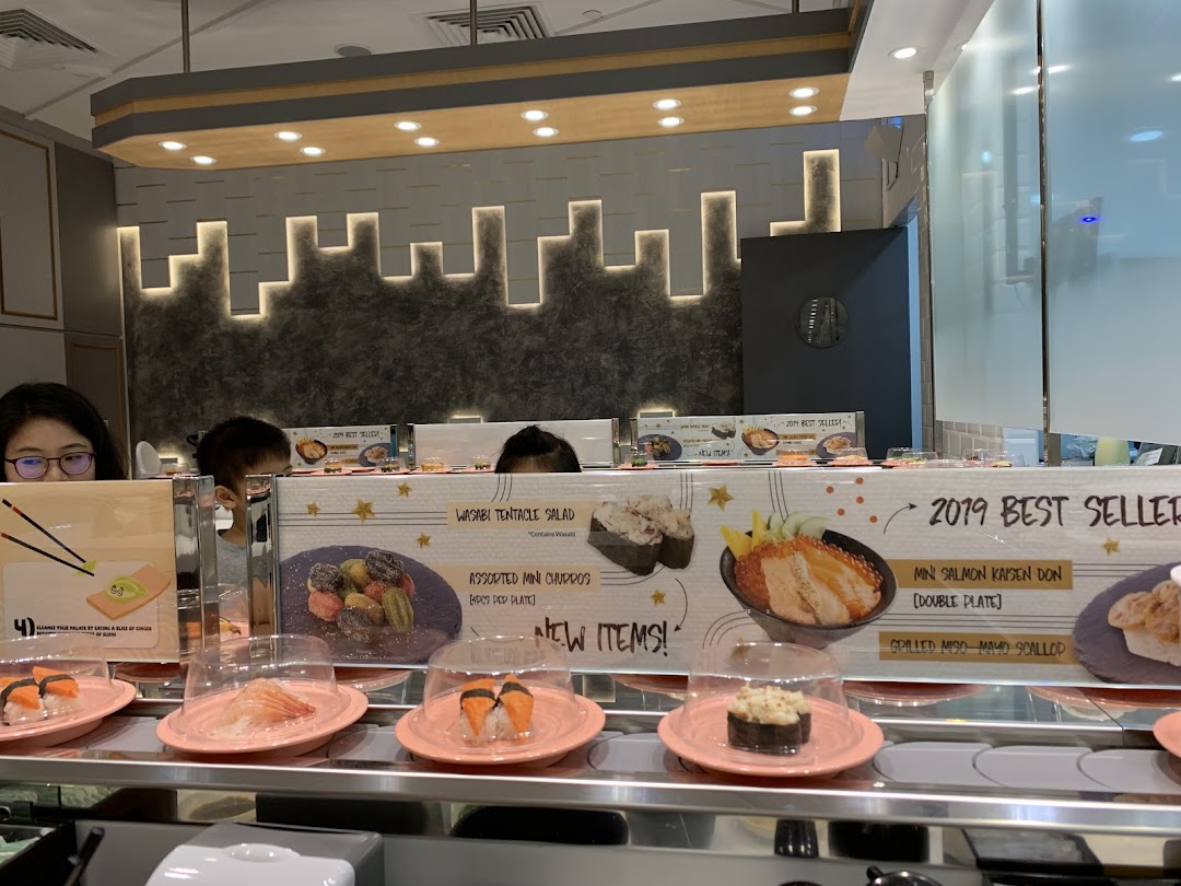 Diners enjoying sushi from a conveyor belt at Sushi Express, featuring promotional items.