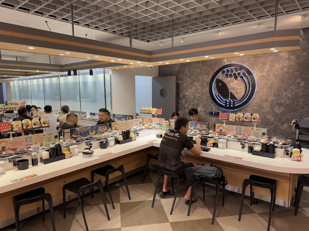 Customers enjoy fresh sushi from a conveyor belt at Sushi Express, featuring a modern interior.