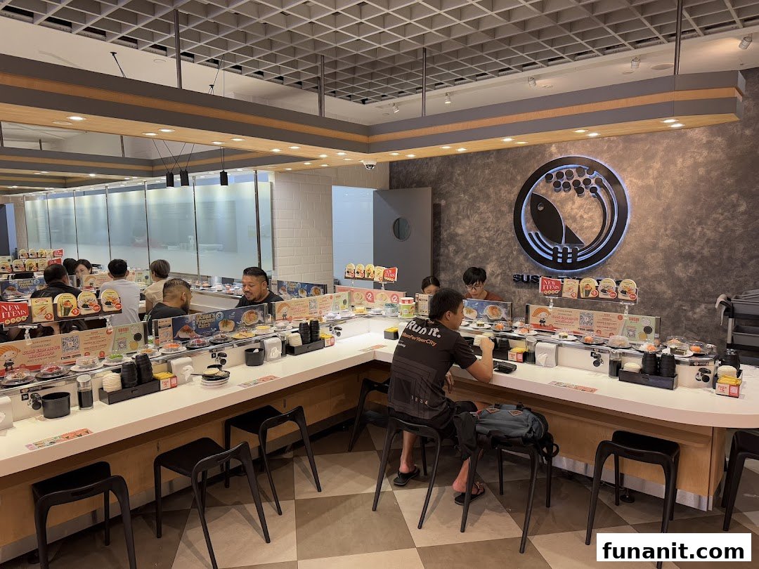 Customers enjoy fresh sushi from a conveyor belt at Sushi Express, featuring a modern interior.