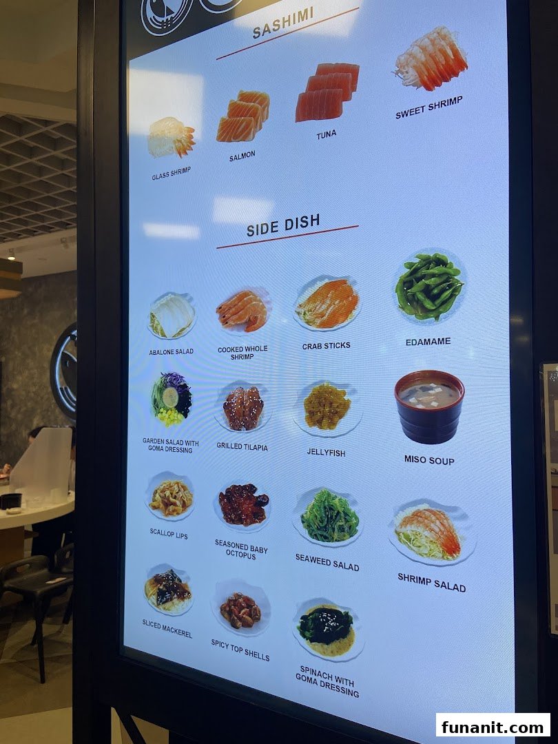 A digital menu board showcasing a variety of sashimi and side dishes with appealing images.