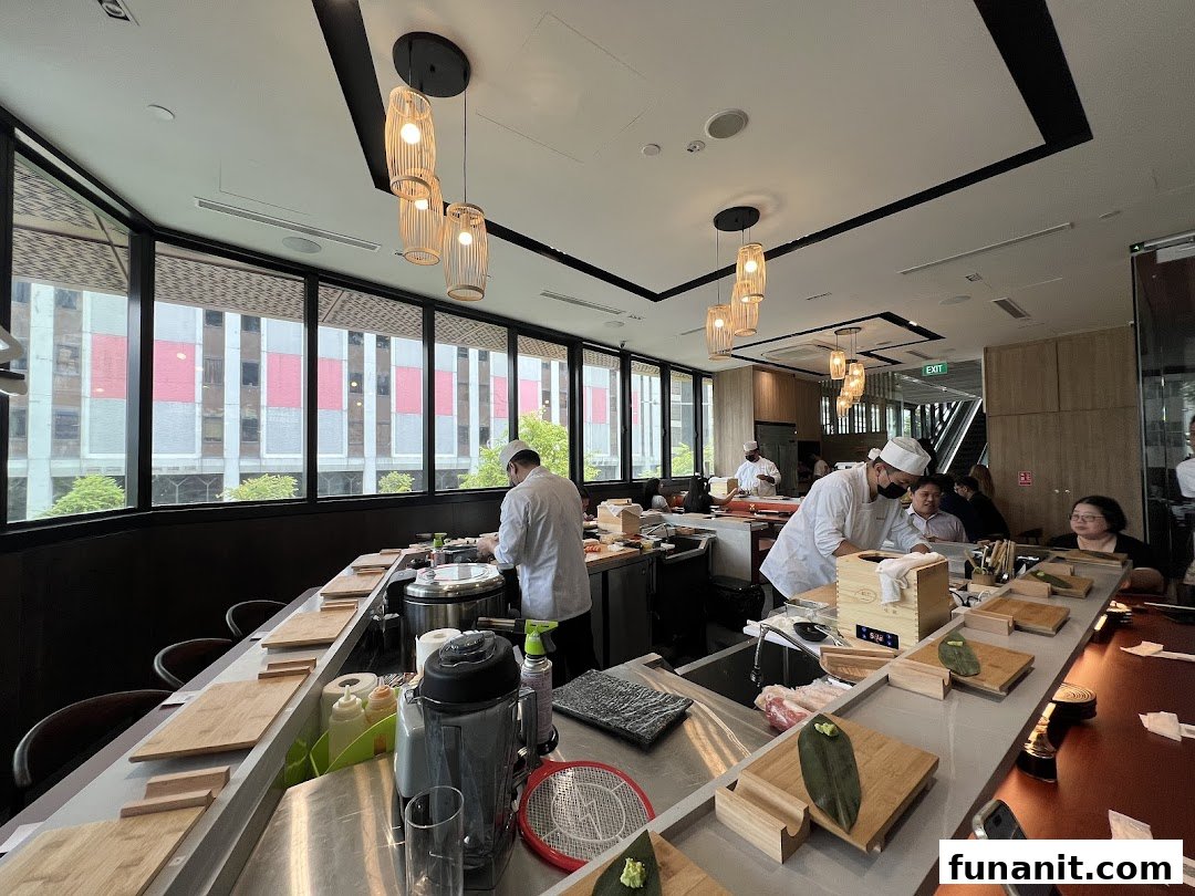 Chefs meticulously prepare fresh sushi at a vibrant counter, offering an engaging dining experience at Sushi Zushi.