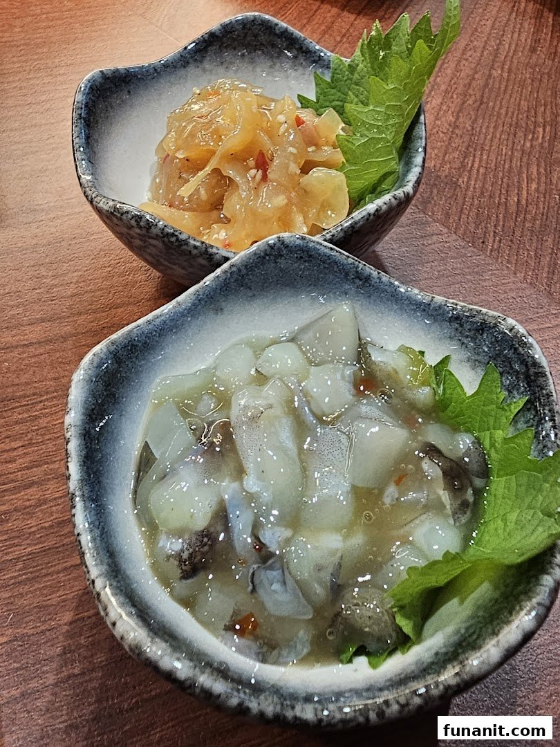 Two small bowls of traditional Japanese appetizers, featuring seasoned jellyfish and squid, served on a wooden table.