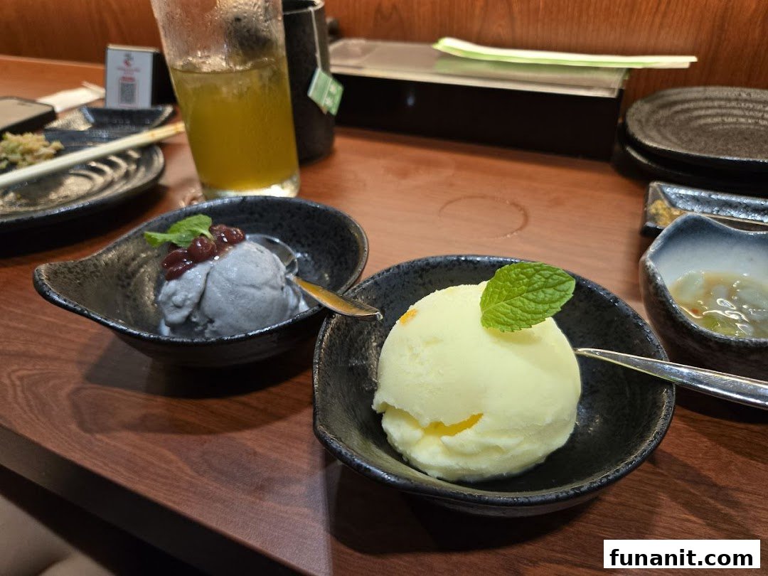 Two scoops of ice cream, one dark with red beans and one light with mint, served in bowls on a wooden table.
