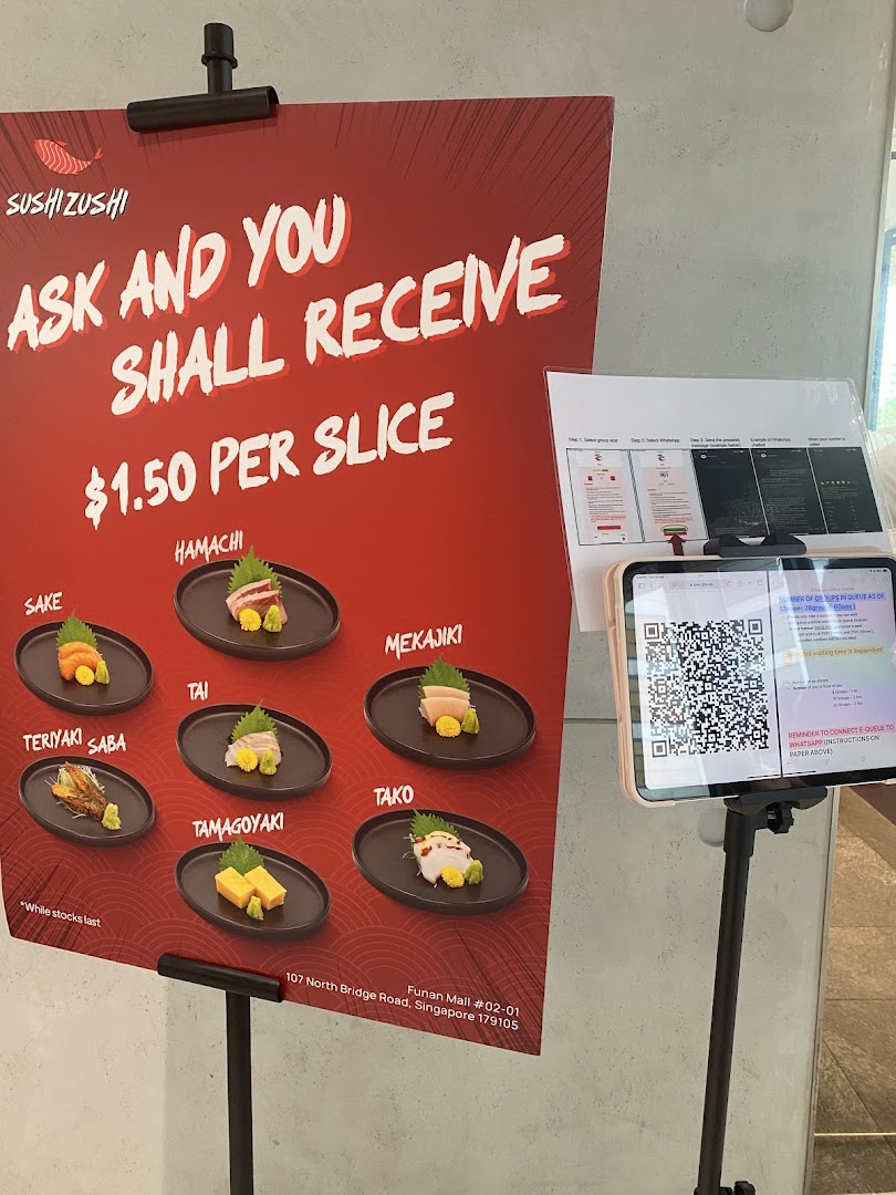 A promotional stand displaying sushi slices available for $1.50 each, with a QR code for e-queue.