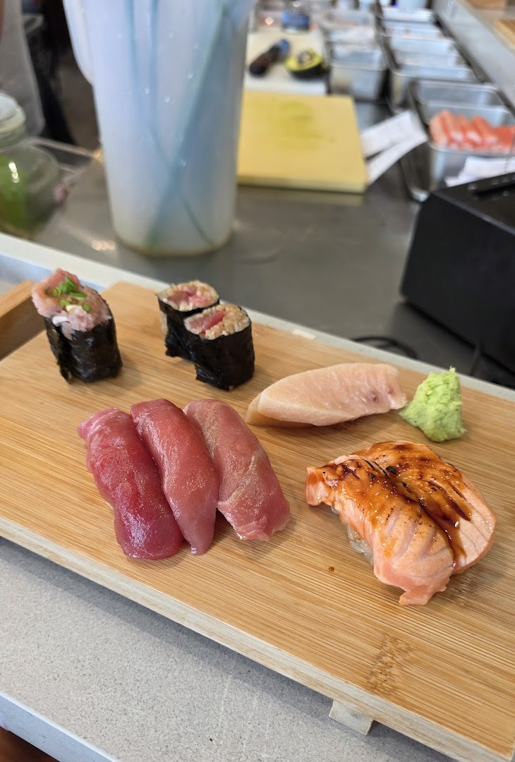 A delicious assortment of fresh sushi and sashimi served on a wooden board.