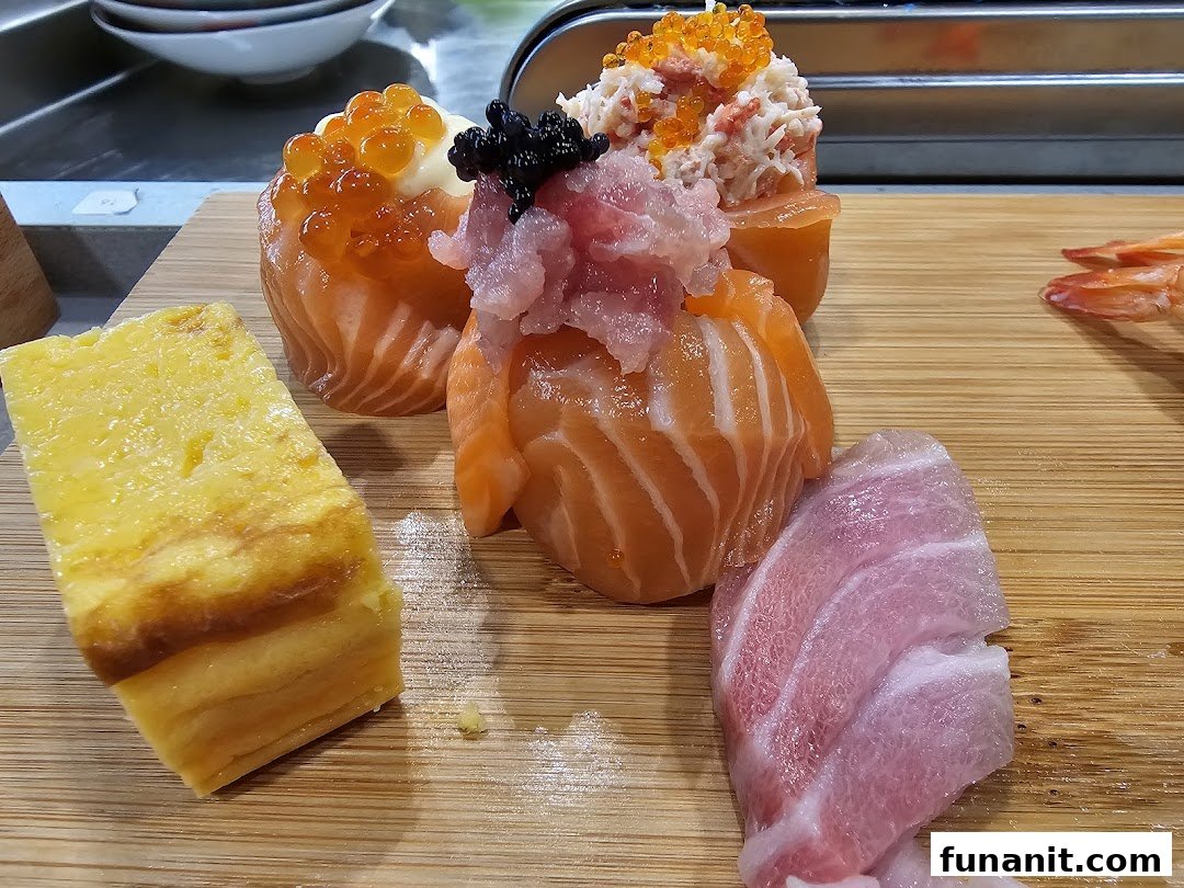 A close-up of fresh sushi and sashimi pieces, including salmon, tuna, and tamagoyaki, on a wooden board.