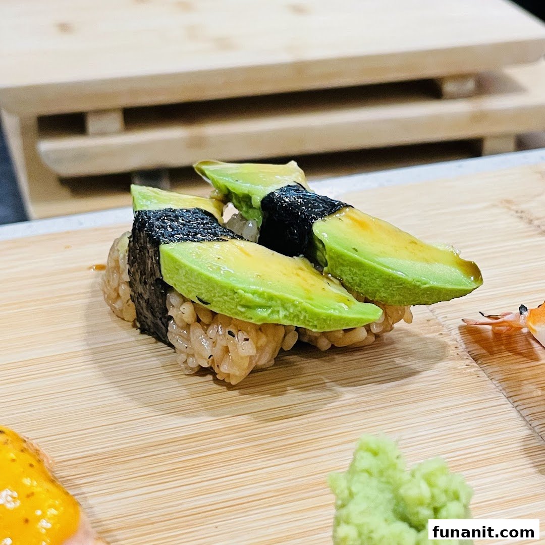 Close-up of fresh avocado sushi served on a wooden board with wasabi.