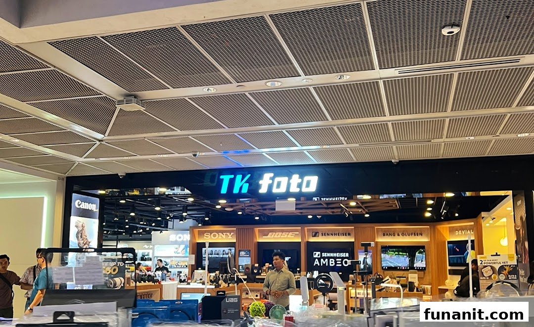 The shop front of TK Foto Technic, showcasing cameras, audio equipment, and electronics brands.