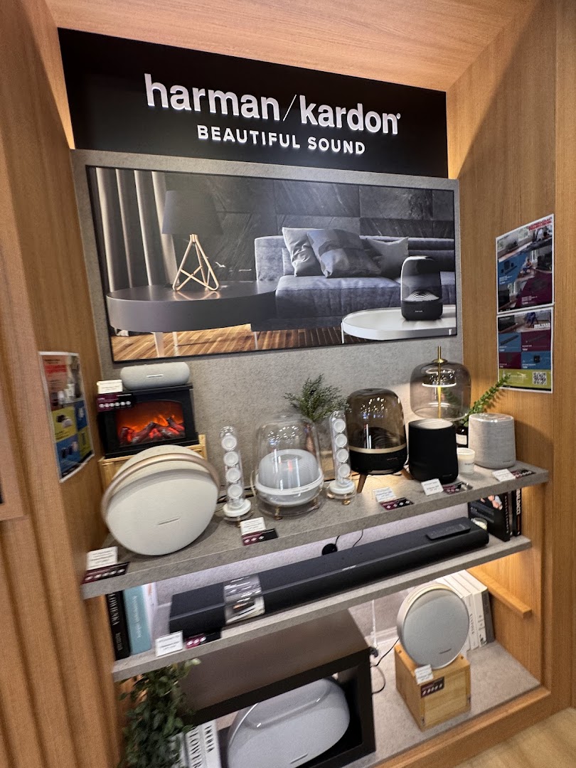 A display of Harman/Kardon audio products, including speakers and soundbars, showcasing beautiful sound technology.