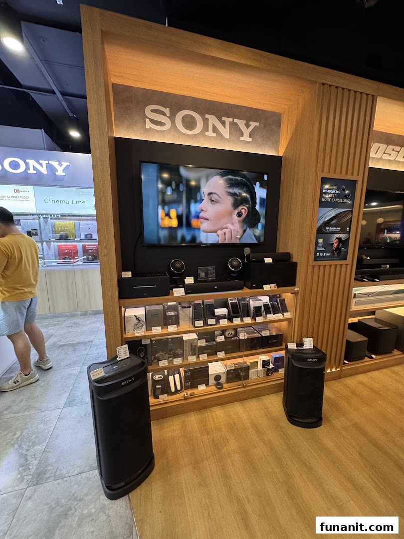 A vibrant in-store display showcasing Sony audio products, including speakers, headphones, and soundbars, with a promotional screen.