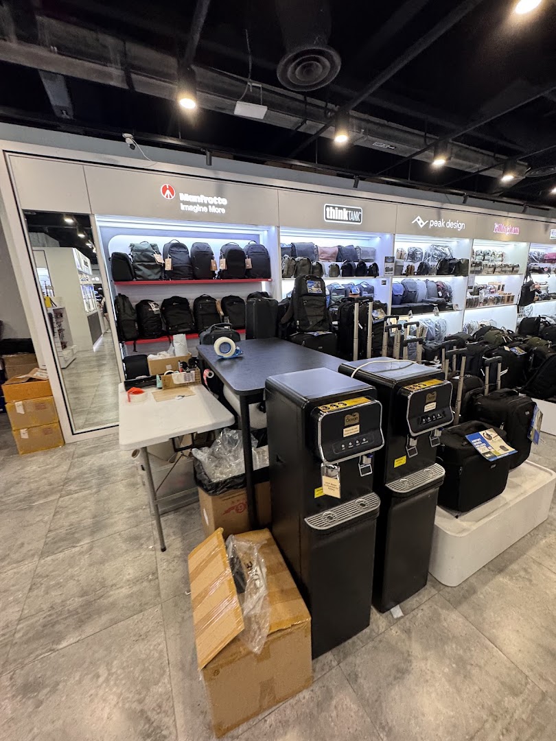 Interior of T K Foto Technic, displaying camera bags and photography accessories from brands like Manfrotto and Peak Design.