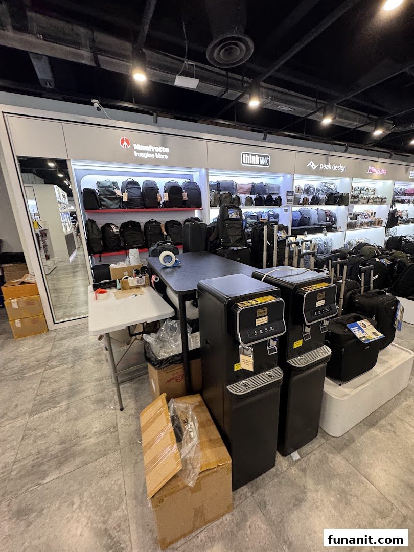 Interior of T K Foto Technic, displaying camera bags and photography accessories from brands like Manfrotto and Peak Design.