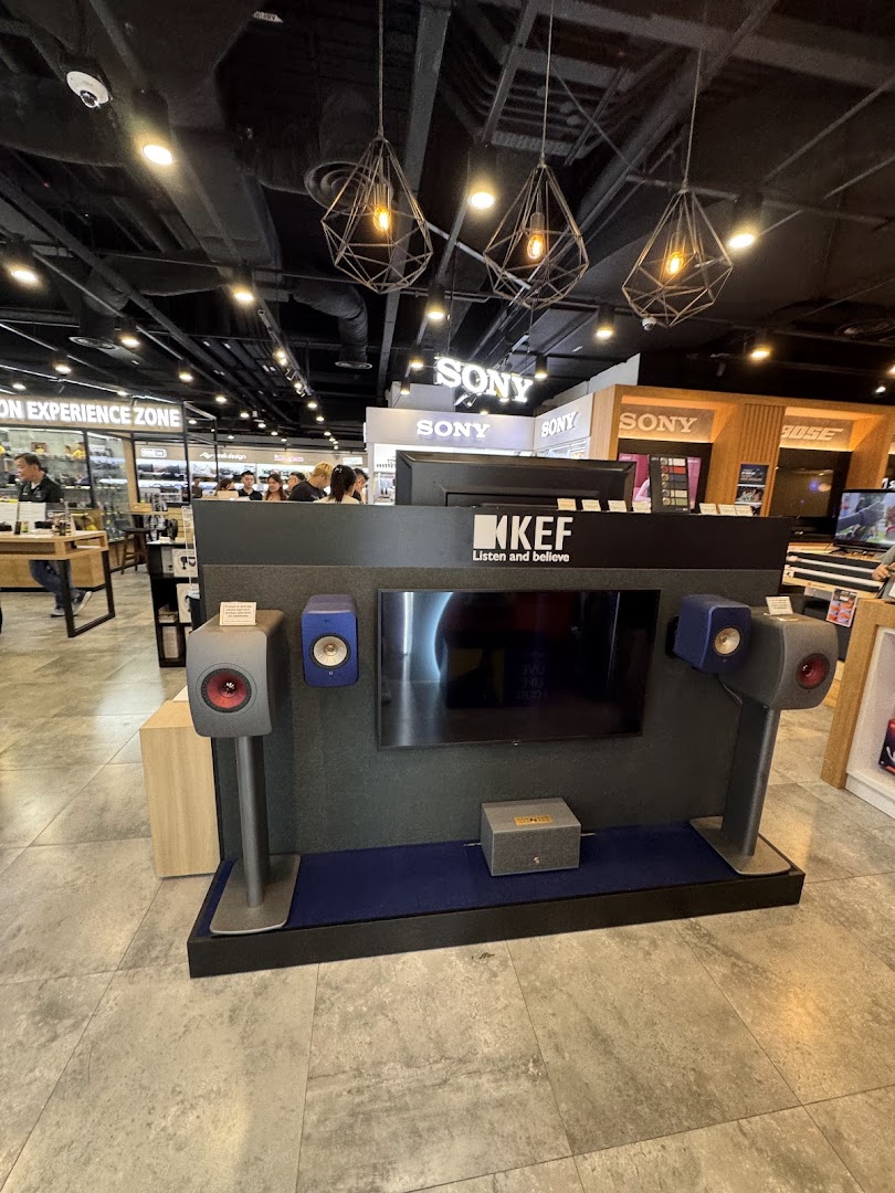 A KEF audio display featuring high-fidelity speakers and a screen, showcasing premium sound equipment in an electronics store.